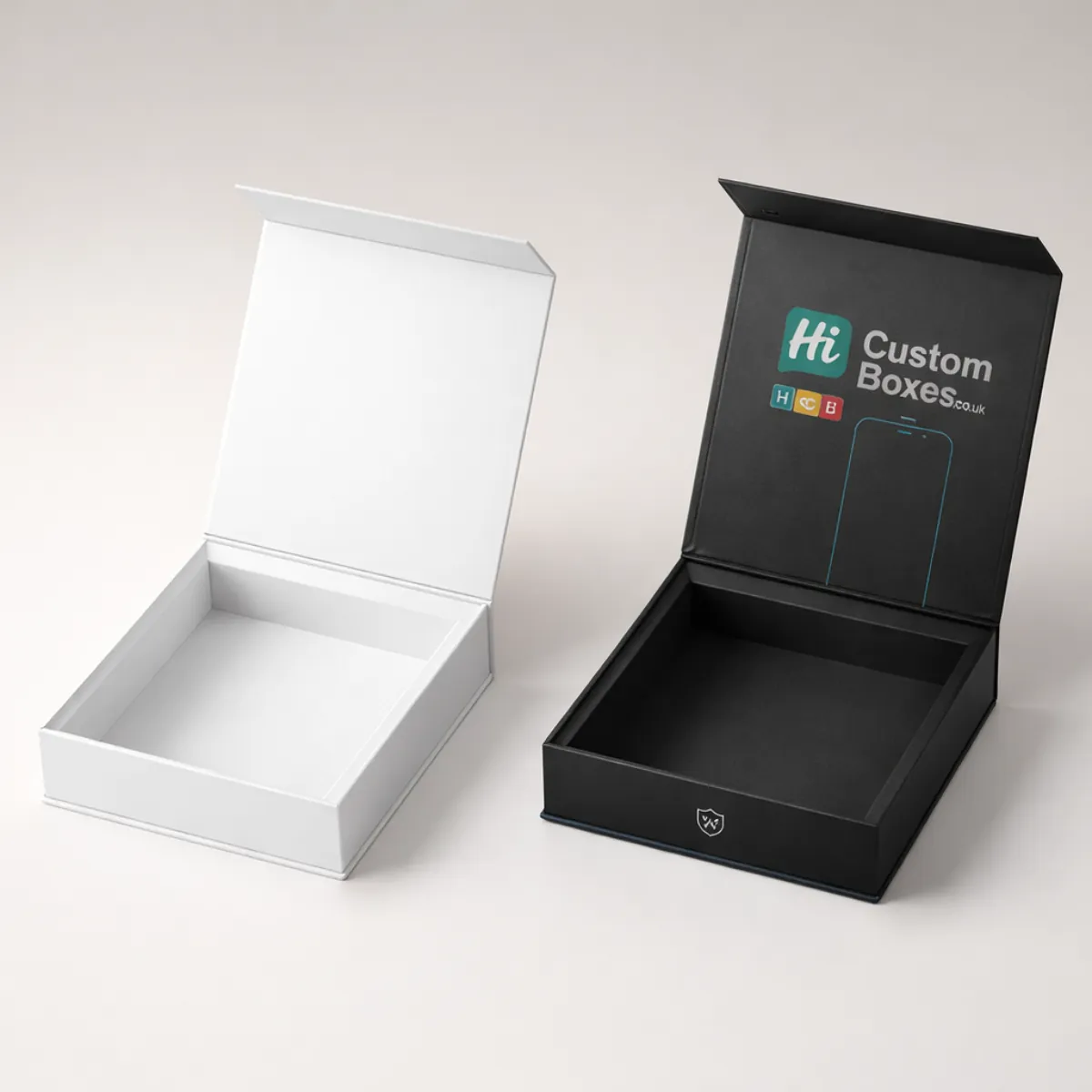 Two open square rigid boxes, one white and one black, showing the premium branded interior lid. class=